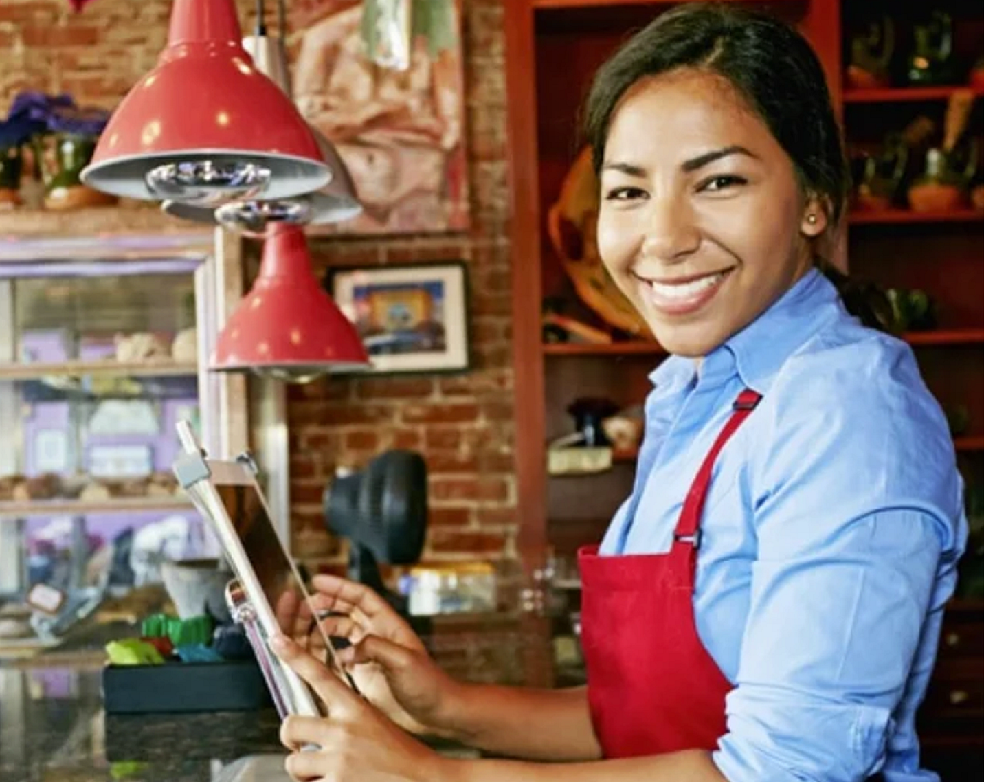 woman with red apron serving customers